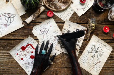 Kahverengi tahta arka planda sihirli özellikleri olan kanlı kara cadı elleri, üst manzara. Cadılar Bayramı