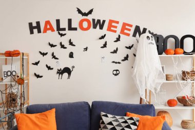 Cadılar Bayramı için hayaletler ve balkabaklarıyla dekore edilmiş modern oturma odasının içi.