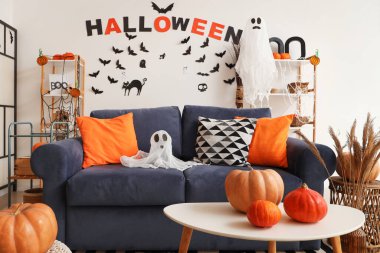 Cadılar Bayramı için hayaletler ve balkabaklarıyla dekore edilmiş modern oturma odasının içi.