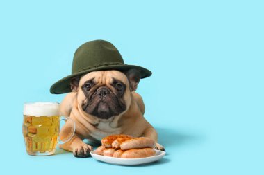 Mavi arka planda duran bir kupa bira ve sosisli şapkalı şirin Fransız bulldog 'u. Ekim Festivali Kutlaması