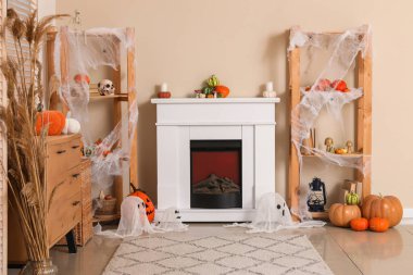 Oturma odasında farklı Cadılar Bayramı süslemeleri olan raflar, tuvalet ve şömine.