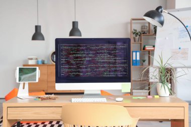 Kodlu bilgisayar monitörü ve ofisteki programcının masasına yerleştirme