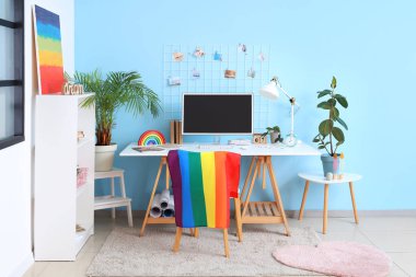 Interior of office with workplace, LGBT flag and painting