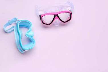 Mor arka planda farklı yüzme maskeleri