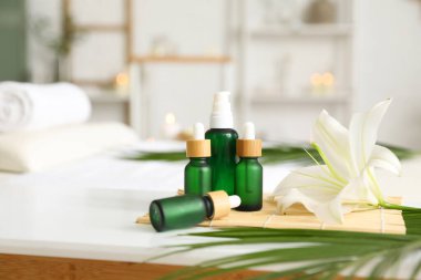 Kuaför salonundaki masada kozmetik şişeleri olan spa kompozisyonu, yakın plan.
