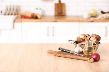 Taze mantarlı kolatör ve mutfak masasında pişirme aletleri.