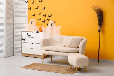 Cadılar Bayramı için dekore edilmiş oturma odasının içi kanepe ve çekmecelerle dolu.