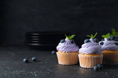 Böğürtlenli lezzetli kekler ve siyah arkaplanda nane şekeri.