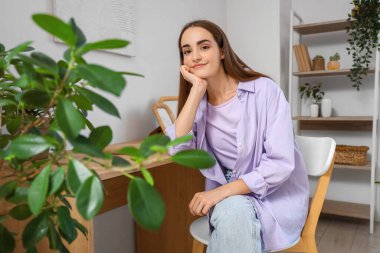 Evdeki masada oturan genç ve güzel bir kadın.