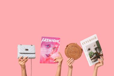 Farklı dergilere sahip kadın elleri ve pembe arka planda şık çantalar.