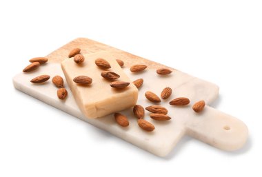 Beyaz arka planda badem ezmesi ve badem fıstıklı kesme tahtası.
