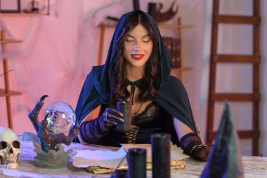 Evinde yanan mumla genç cadı.