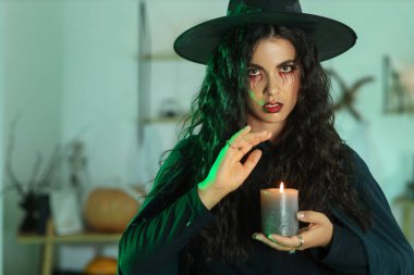 Evinde yanan mumla genç cadı.