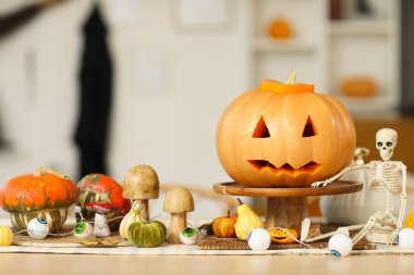 Yemek masasında Cadılar Bayramı süsüyle oyulmuş balkabağı.