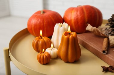 Evdeki taburede balkabağı şeklinde mum yakmak, yakın çekim.