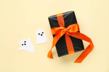 Bej arka planda kağıt hayaletler olan Cadılar Bayramı hediyesi. Üst görünüm