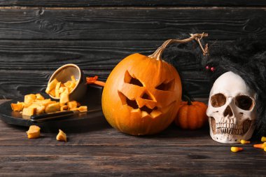 Kahverengi ahşap arka planda süslemeli Cadılar Bayramı balkabağı