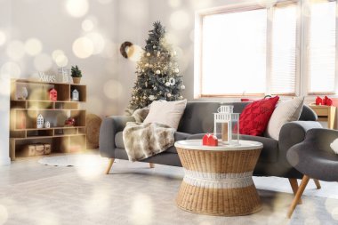 Gri kanepesi, Noel ağacı ve şenlikli süslemeleri olan oturma odasının içinde.