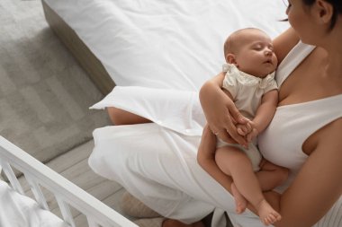 Mutlu anne ve küçük bebeği yatak odasında.