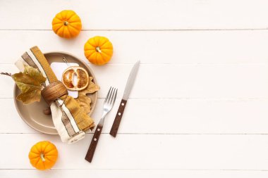 Beyaz ahşap arka planda balkabakları ve kurumuş yapraklarla sonbahar masası ayarı