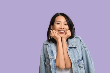 Genç Asyalı kadın leylak arka planda gülüyor