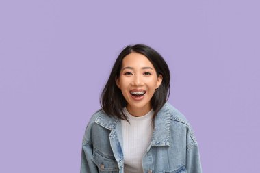 Genç Asyalı kadın leylak arka planda gülüyor