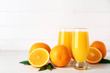 Beyaz ahşap arka planda taze portakal suyu bardakları