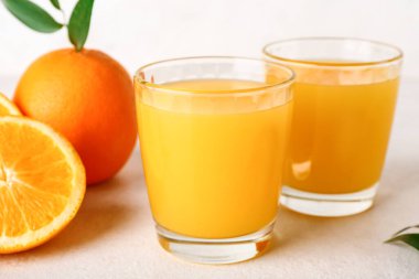 Taze portakal suyu ve beyaz arkaplanda yapraklar