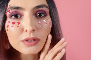 Pembe arka planda güzel makyajlı peruklu genç bir kadın. Sevgililer Günü kutlaması