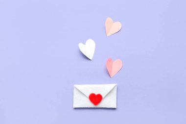 Gri arkaplanda Sevgililer Günü için kağıt kalpler ve zarf içeren kompozisyon