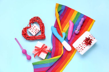 Seks oyuncakları ve mavi arka planda hediyeleri olan gökkuşağı LGBT bayrağı. Sevgililer Günü kutlaması