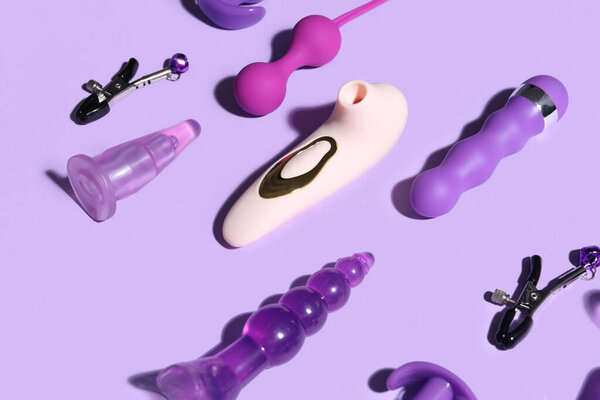 Много разных секс-игрушек на фиолетовом фоне