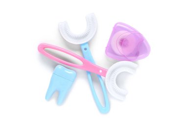 Beyaz arka planda diş ipiyle çocuk diş fırçaları ve diş modeli.