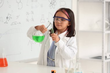 Fen sınıfında kimya deneyi yapan tatlı küçük bir kız.