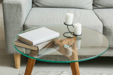 Oturma odasındaki sehpanın üzerinde mumları yakmak, yakın çekim.