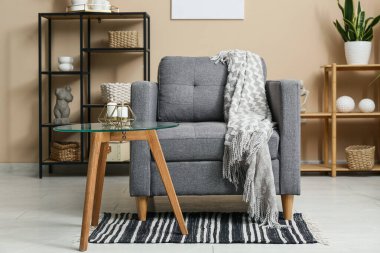 Koltuğu, sehpası ve yanan mumları olan modern oturma odasının içinde.