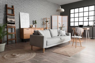 Ahşap merdiveni, kanepesi ve raf ünitesi olan oturma odasının içinde.