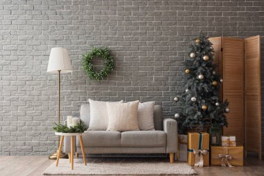 Oturma odasının içinde kanepe, lamba ve Noel ağacı var.