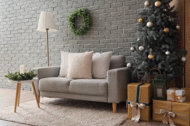 Oturma odasının içinde kanepe, lamba ve Noel ağacı var.