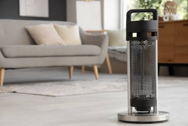 Oturma odasında yerde elektrikli ısıtıcı, yakın çekim.