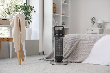 Yatak odasının yanında yerde elektrikli ısıtıcı var.