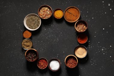 Koyu arkaplanda taze baharat bulunan kaselerden yapılmış çerçeve.