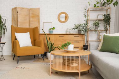 Oturma odasının içinde ayna, koltuk ve çekmeceler var.