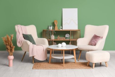 Beyaz koltukları, puf ve sehpası olan güzel bir oturma odası.