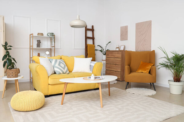 Интерьер гостиной с деревянной лестницей, желтым диваном и креслом