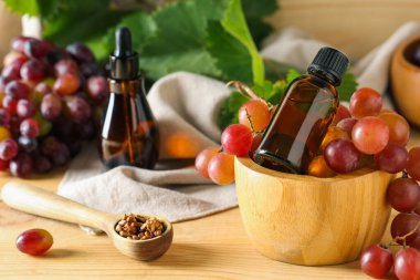 Ahşap zemin üzerinde kozmetik üzüm tohumu yağı şişeleri