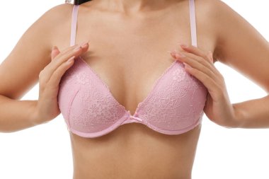 Beyaz arka planda pembe sütyenli genç bayan, yakın plan.