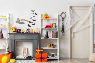 Koridorun içinde Cadılar Bayramı süslemeleri olan şömine ve raflar.