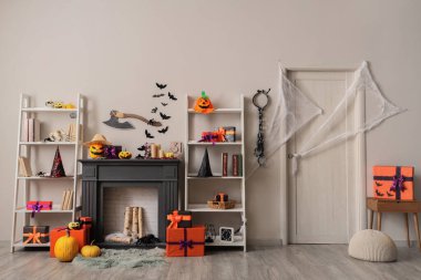 Koridorun içinde Cadılar Bayramı süslemeleri olan şömine ve raflar.