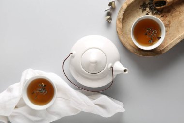 Çay demliği, ahşap tepsi ve beyaz arka planda peçete kompozisyonu